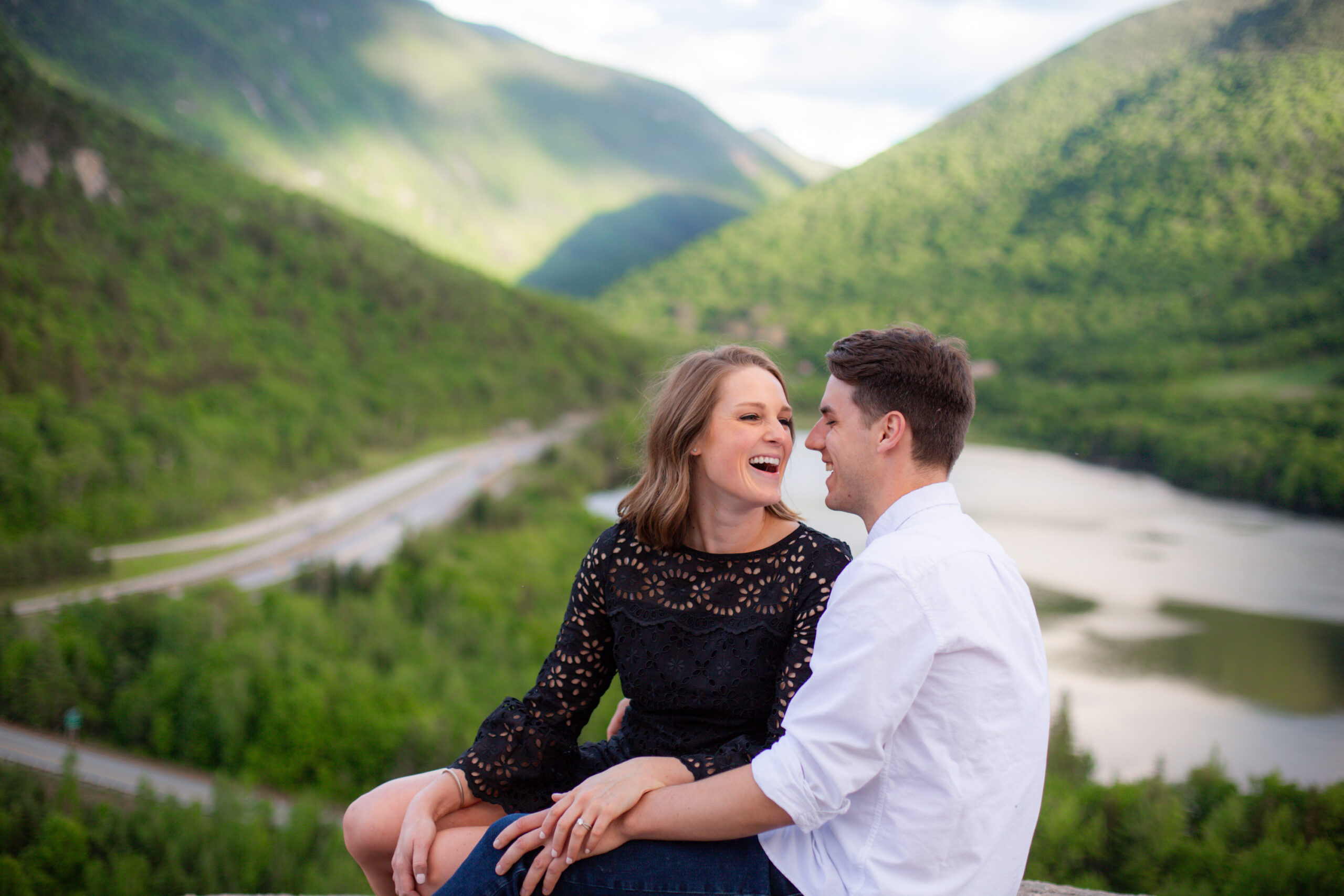 candid photo of a couple laughing in the white mountains of NH during their engagement session. photographed by Chiha Studios.