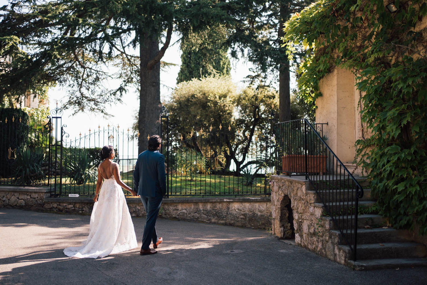 Newlyweds walk holding hands while exploring the Domaine du Mont Leuze grounds