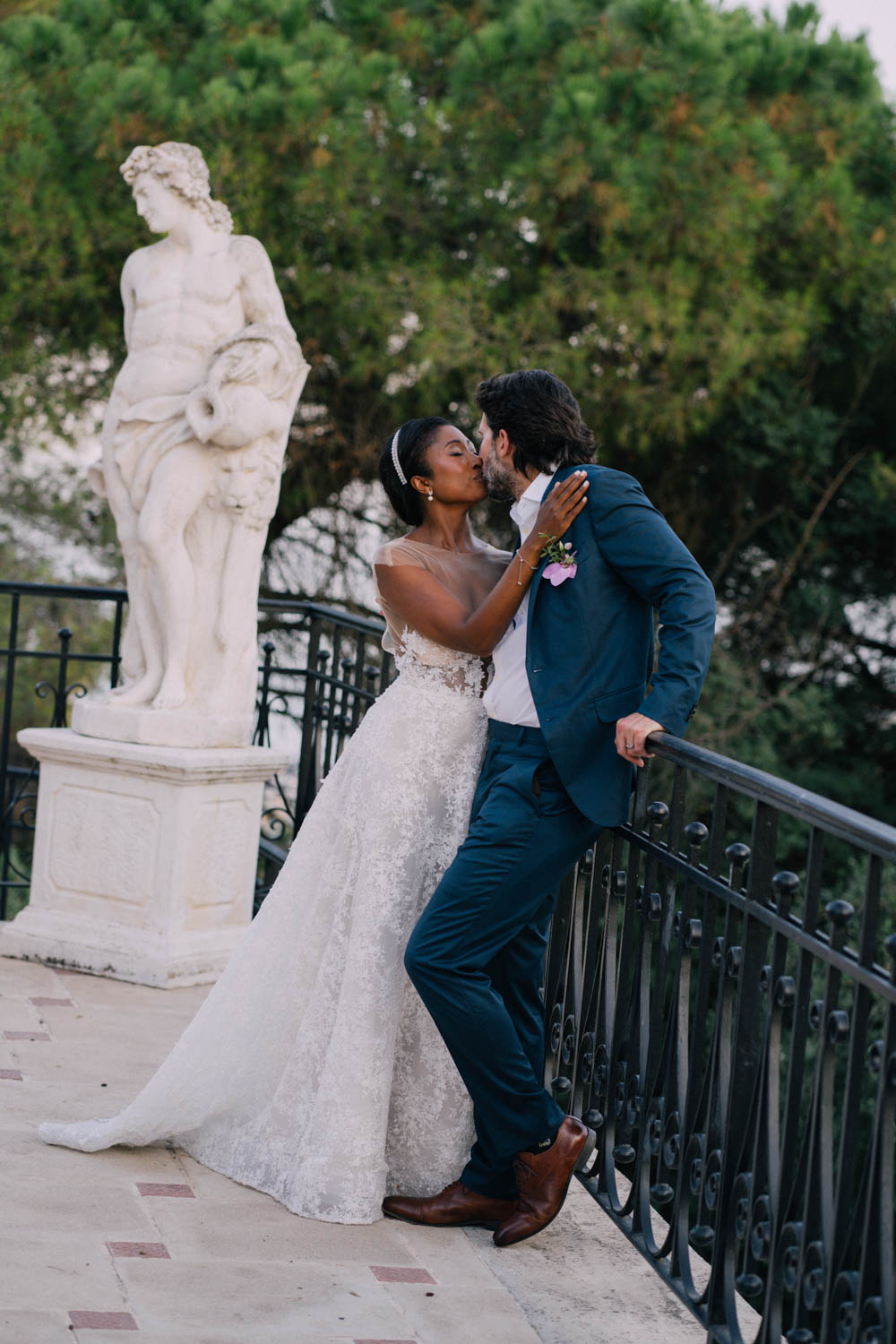 A bride kisses her groom in a garden patio