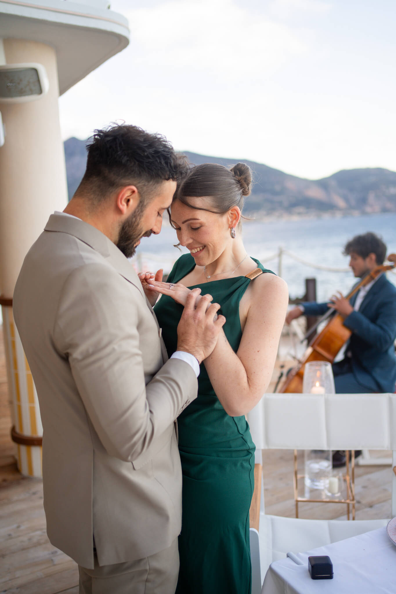 A woman snuggles and admires her engagement ring on her finger on a balcony directly after their French Riviera Proposal