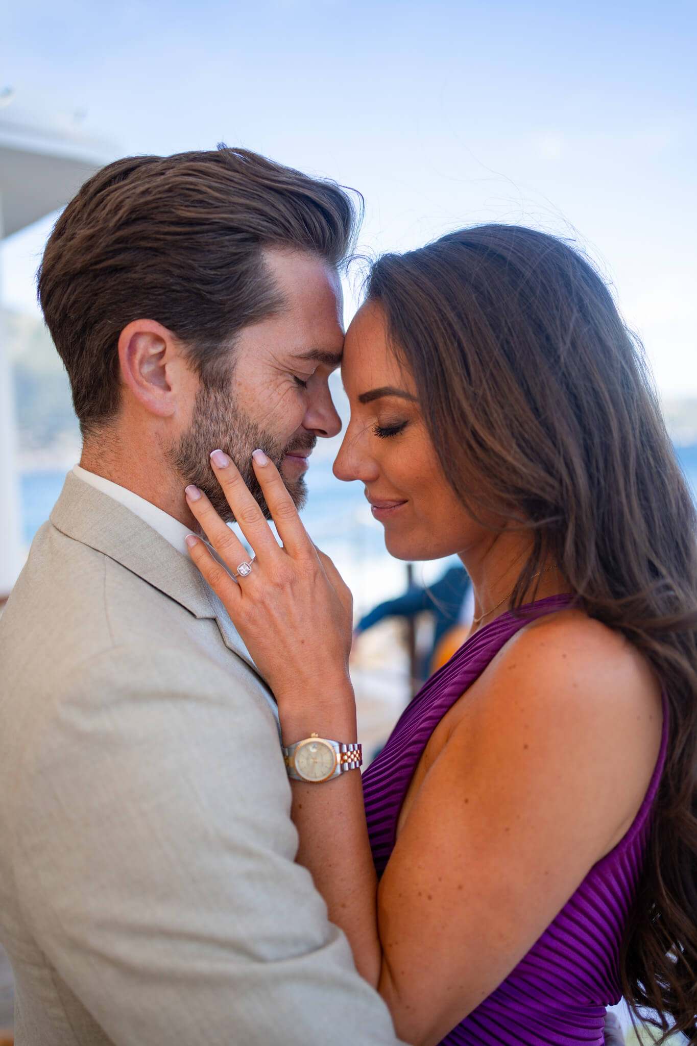Newly engaged couple snuggle in a purple dress and tan suit during their French Riviera Proposal