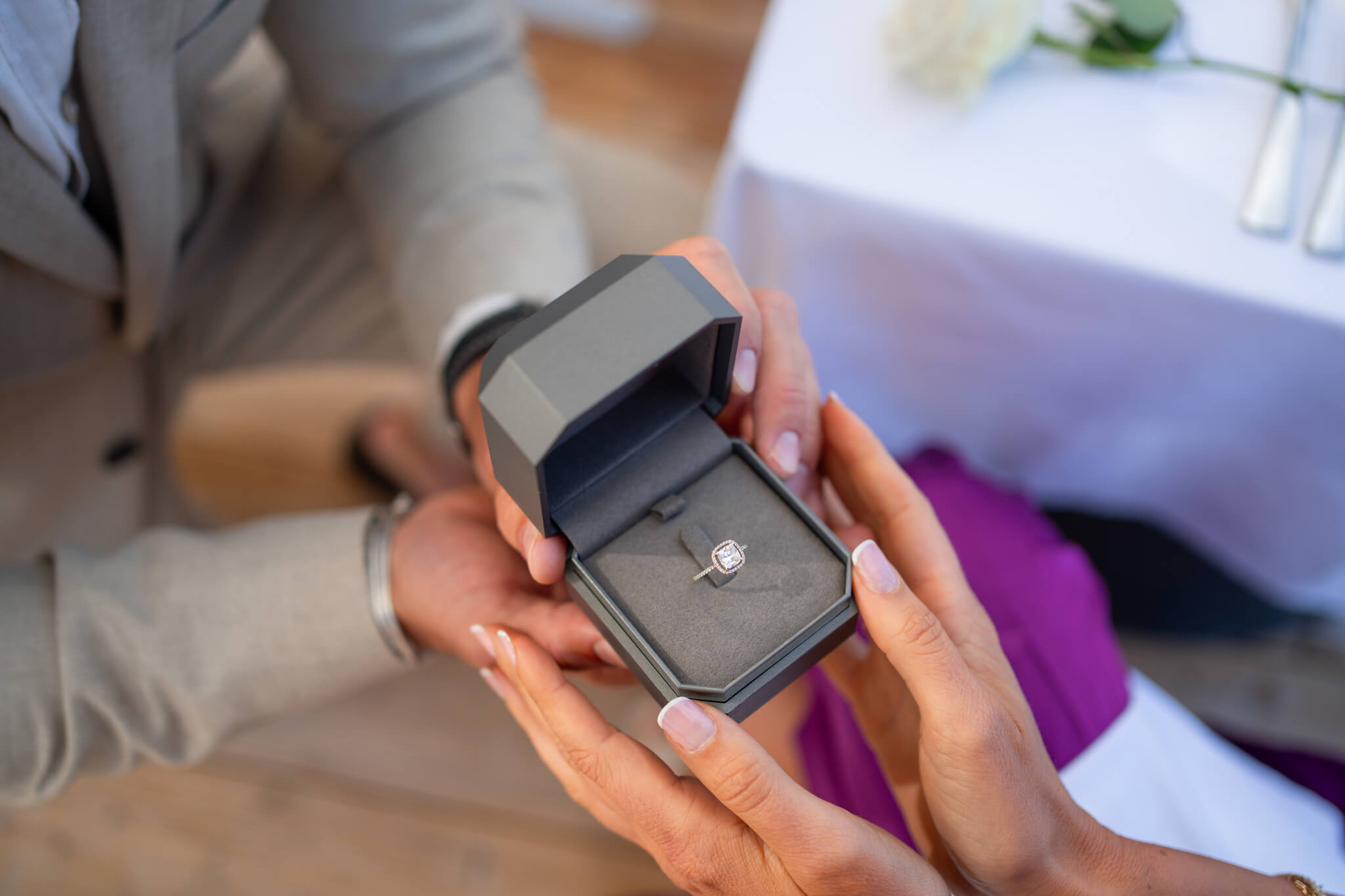 Details of a couple with hands on a ring box